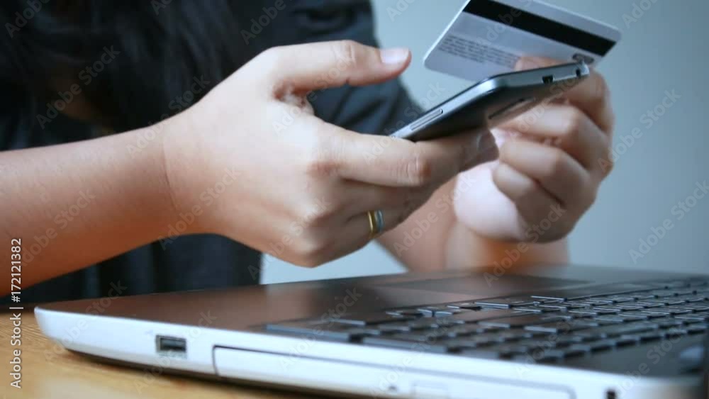 Close up shot hands of woman using smart phone and holding credit card metaphor internet shopping mobile application and e business concept