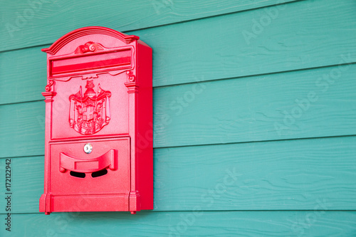 Red mailbox on classic green woonden background