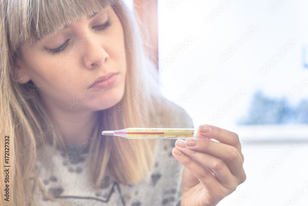 sick young woman suffering fever checking thermometer sick young woman suffering fever checking thermometer