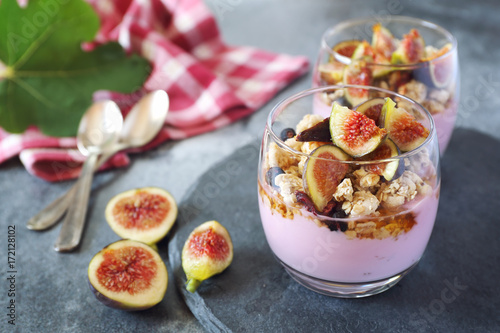 Two glasses of fruit yogurt with granola, figs and honey
