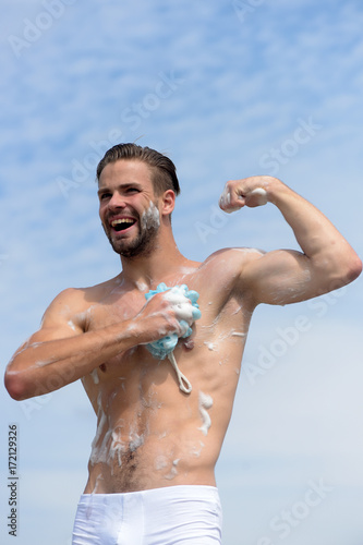 Man with bristle laughing and showing muscles