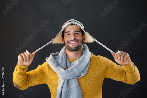 Quadro em tela Portrait of smiling man holding wooly hat
