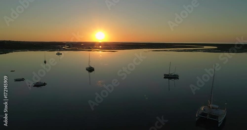 Sunrise aerial seascape, in Ria Formosa wetlands natural park, shot over Cavacos beach. Algarve.