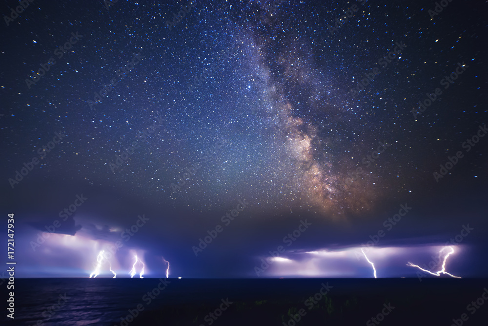 Thunderstorm on sea and milky way night sky