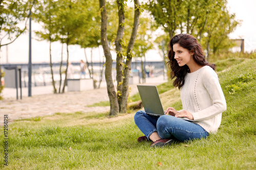 Young woman with laptop in park