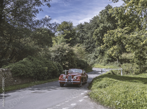 Vintage Car Driving Down Country Road