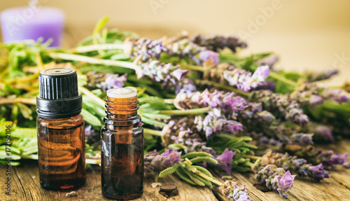 Fresh lavender and essential oil on wooden background