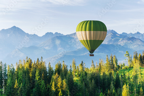 Fantastic snow-capped mountains in the beautiful cumulus clouds. A balloon in the background. Carpathians. Ukraine photo