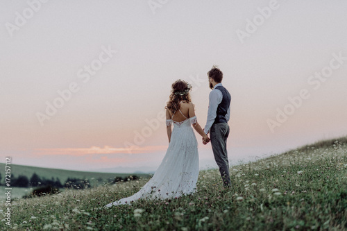 Beautiful bride and groom at sunset in green nature.
