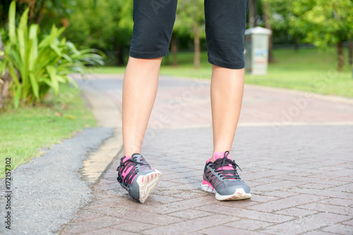 Sporty woman ankle sprain while jogging or running at park.