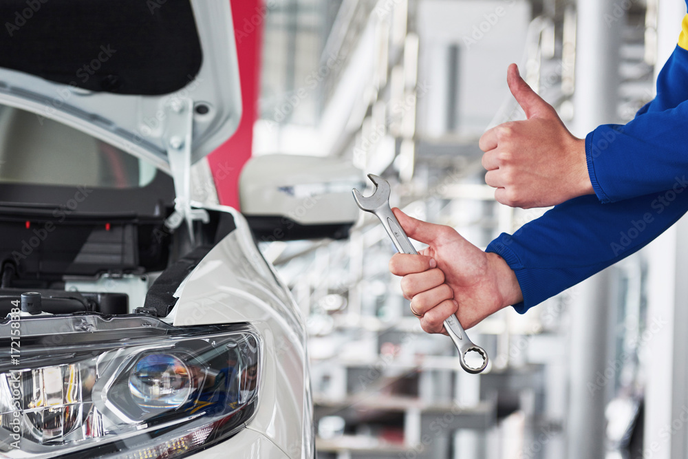 Hands of car mechanic with wrench in garage. Hands of car mechanic with wrench in garage.