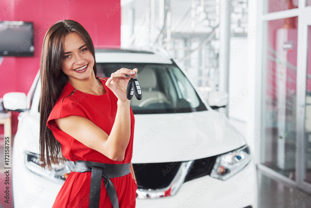 Smiling car salesman handing over your new car keys, dealership and sales concept. Happy girl the buyer Smiling car salesman handing over your new car keys, dealership and sales concept. Happy girl the buyer