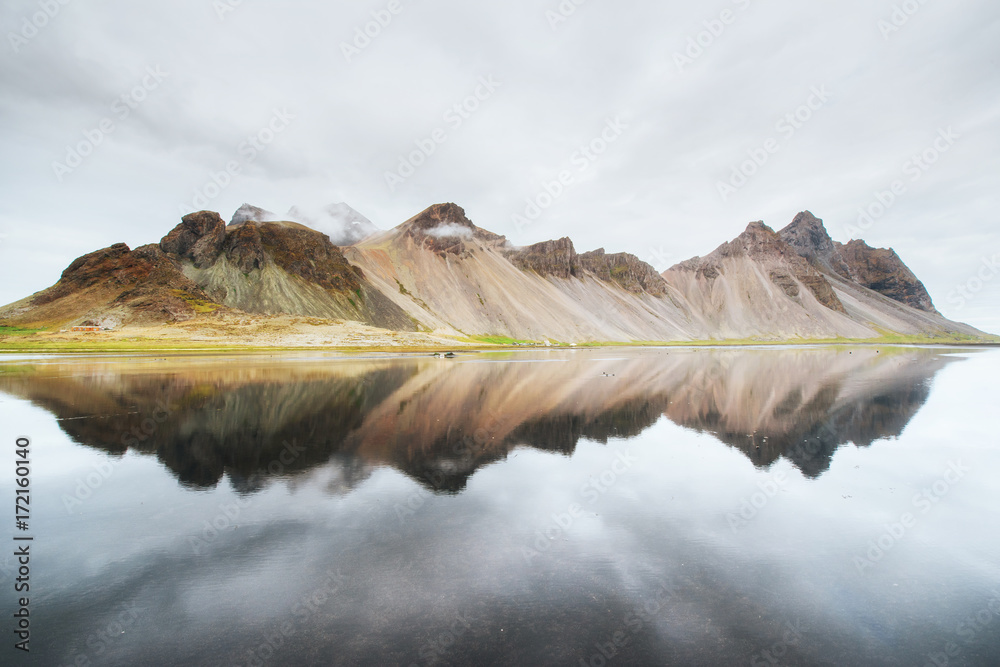 Amazing mountains reflected in the water at sunset. Stoksnes, Iceland - obrazy, fototapety, plakaty 