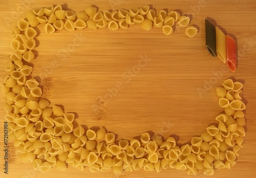 Dry pasta on wood background. Italian flag pasta Penne.