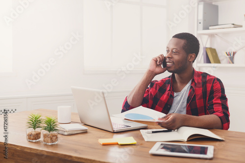 Young black businessman read documents in modern white office