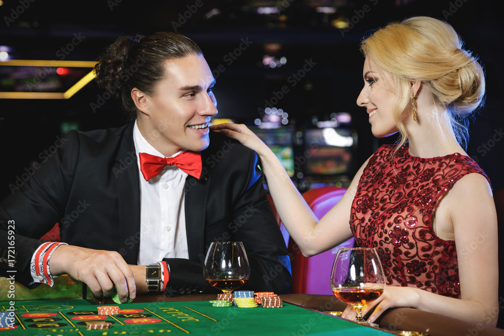 Beautiful and rich couple playing roulette in the casino Beautiful and rich couple playing roulette in the casino