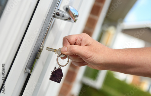 Opening a door to house with key