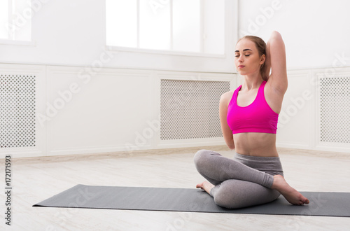 Woman training yoga in cow head pose.