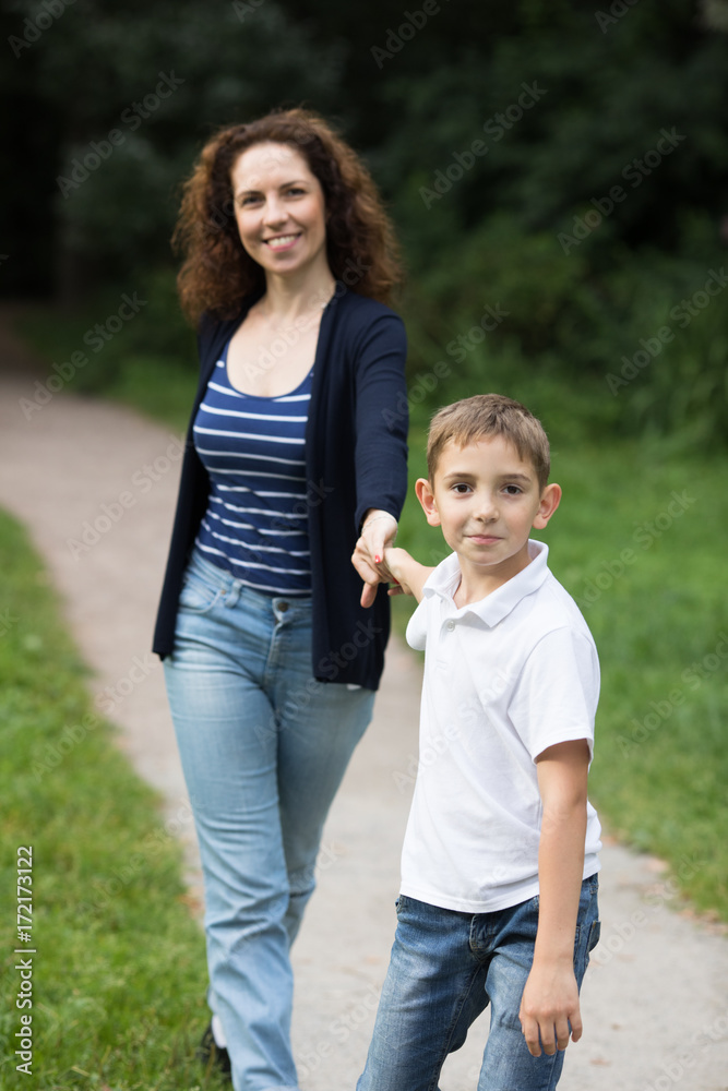 A son is pulling her mother to go faster with him A son is pulling her mother to go faster with him