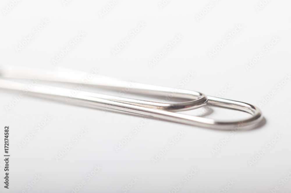 A single silver paperclip on a white background