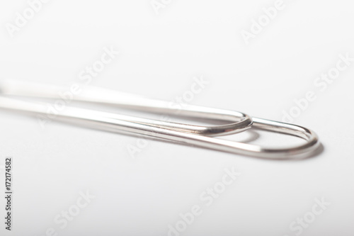 A single silver paperclip on a white background