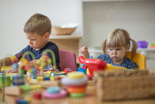 Two chidren are playing at pre school with montessori toys