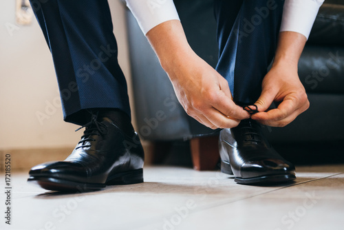 Groom lacing his shoes 