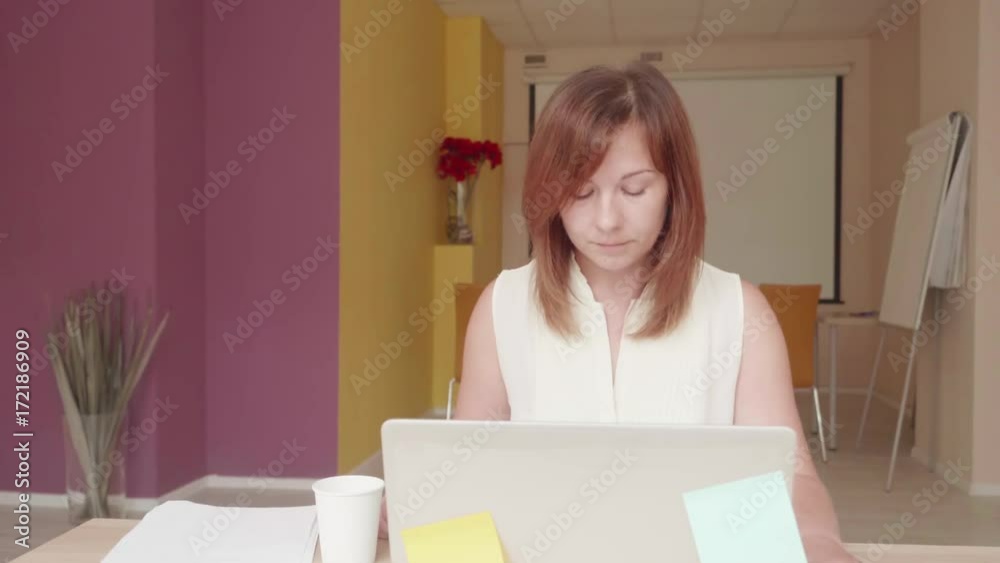Dissappointed woman sits in front of laptop, drinks water and pours water on lap top Dissappointed woman sits in front of laptop, drinks water and pours water on lap top