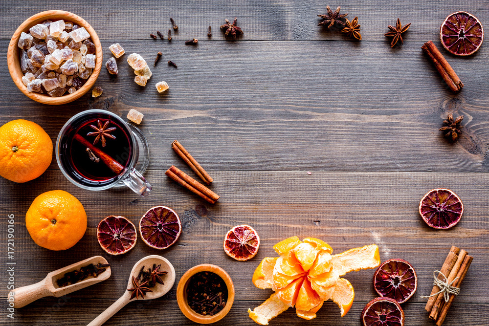 Hot mulled wine or grog cooking for new year celebration with oranges and spices ingredients on wooden background flat lay mock-up Hot mulled wine or grog cooking for new year celebration with oranges and spices ingredients on wooden background flat lay mock-up