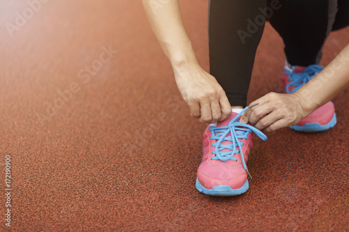 Woman tying shoelaces for running healthy exercise.