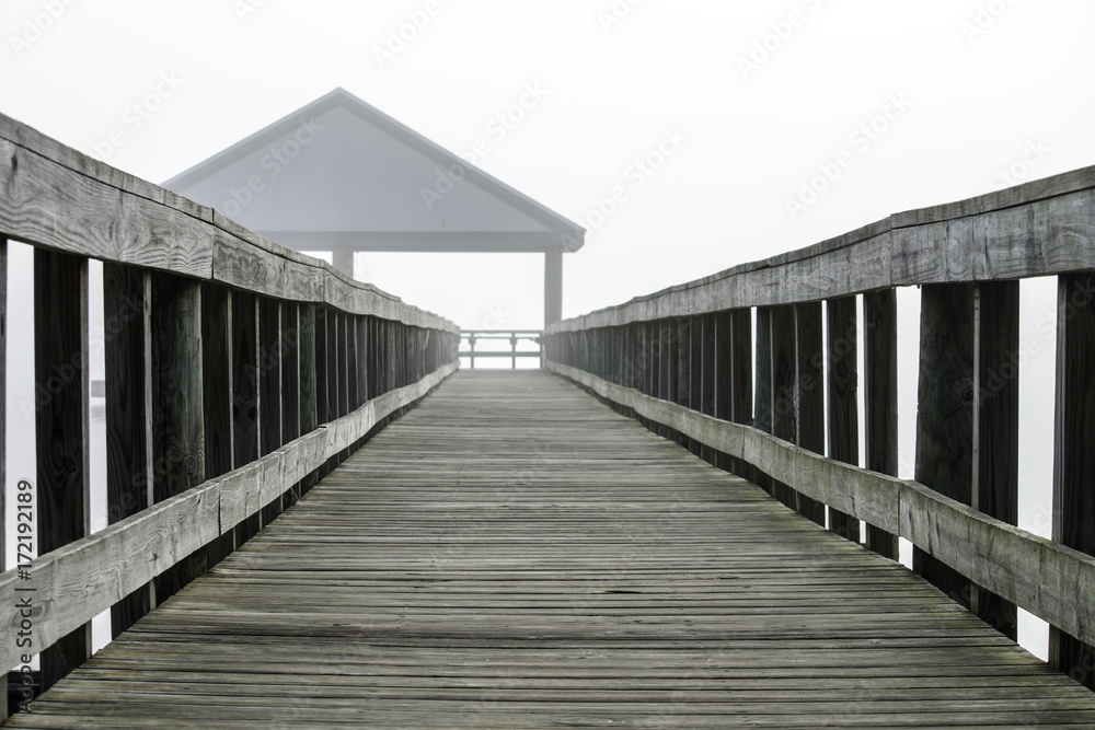 Fototapeta premium Pier leading to a fishing pavilion fading into a mist