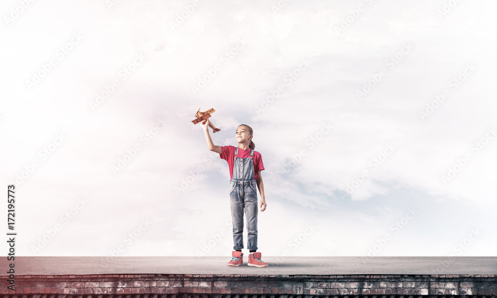 Concept of careless happy childhood with girl dreaming to become Concept of careless happy childhood with girl dreaming to become