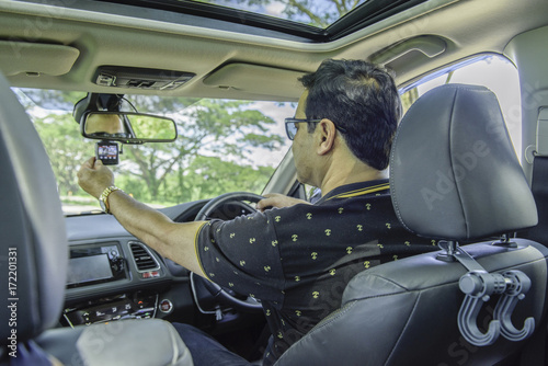 Asian casual man sit in car and sitting car camera ,safety first concept.