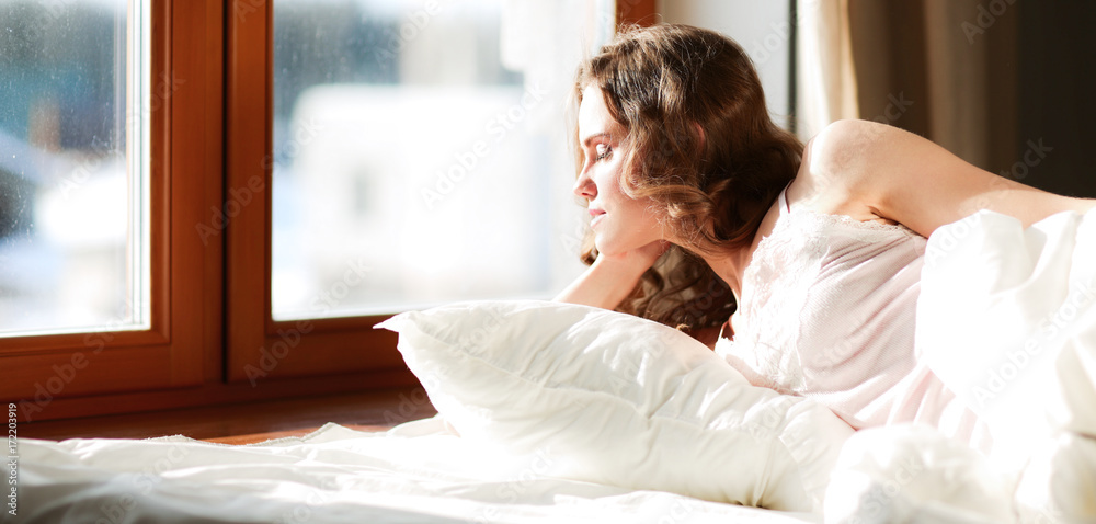 Pretty woman lying down on her bed at home Pretty woman lying down on her bed at home