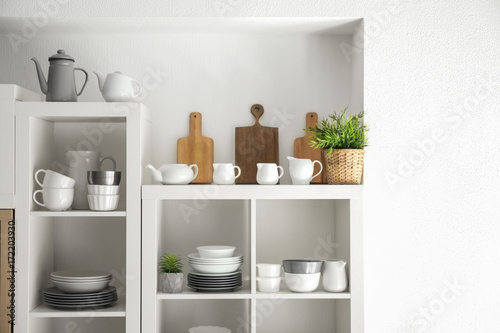 Kitchen shelving with dishes on white wall background