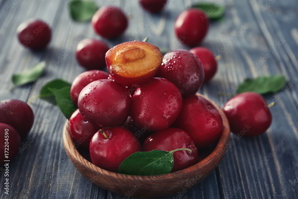 Bowl with ripe fresh plums on wooden table Bowl with ripe fresh plums on wooden table
