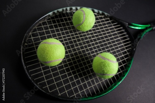High angle view of fluorescent yellow tennis racket and balls © WavebreakMediaMicro