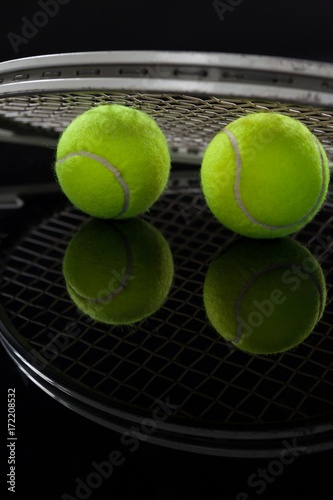 Close up of fluorescent yellow tennis balls with racket with © WavebreakMediaMicro
