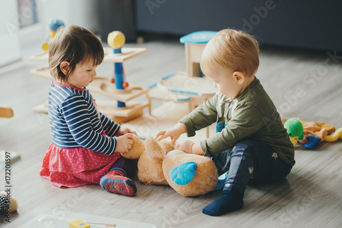 little girl and boy playing with toys by the home