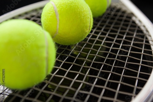 Close up of fluorescent yellow balls on tennis racket © WavebreakMediaMicro