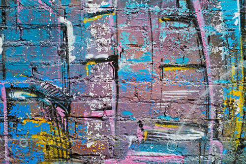 Abstract colorful (blue, purple, yellow, white and black)painted brick wall as background, texture