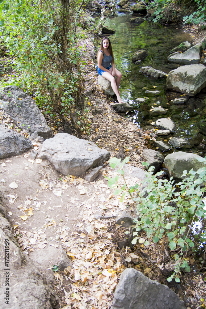 Beautiful woman in nature on the bank of a mountain river Beautiful woman in nature on the bank of a mountain river