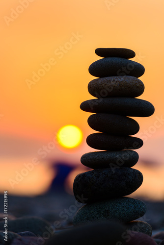 Stones pyramid on sand symbolizing zen  harmony  balance. Black sea at sunset in the background.