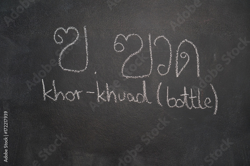 Thai letter written with white chalk on blackboard photo