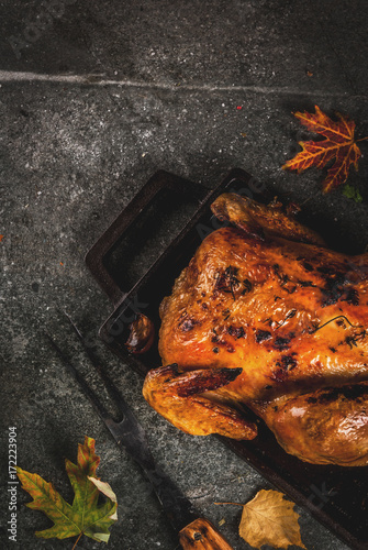 Thanksgiving Day food. Roasted whole chicken or turkey on dark grey background, top view copy space