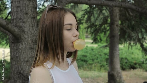 Young pretty girl chews a gum, outdoor, slow motion  