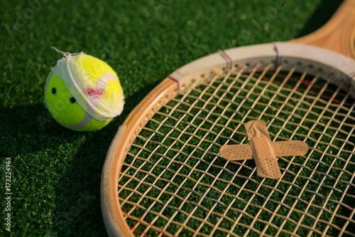 Close up of tennis ball and racket with bandage