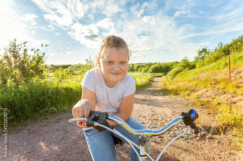 Smiling little girl on a bicycle