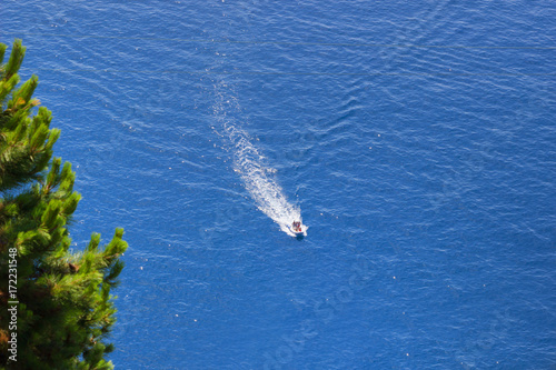 People with high-speed boat in the sea, aerial view, top view, Amazing nature background with blue sea color and beautifully bright day in summer season. © parntawan1987