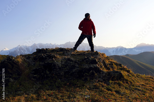 tourist stands on a hill in a mountainous area in Georgia.